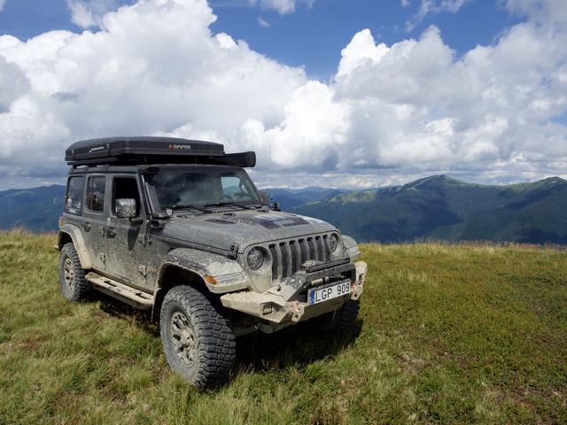 Wrangler aukštikalnių pievoje po kamuoliniais debesimis